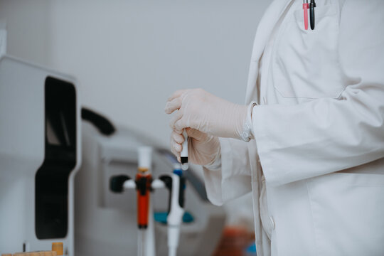 Medical Professional In Lab Coat Wearing Gloves And Preparing A Sample With A Pipette In Laboratory