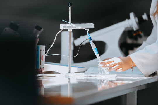 Laboratory Scientist Using Pipette and Flask for Research Experiment in Modern Science Lab