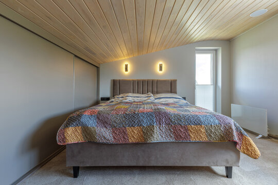 Bedroom Interior with Double Bed and Sloped Wooden Ceiling