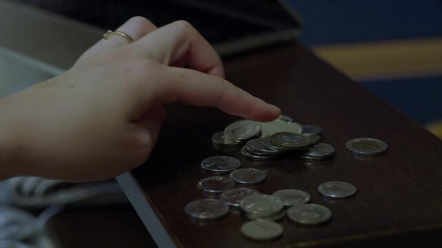 Hand sorting coins on table for personal budgeting