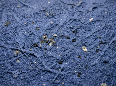 Periwinkle blue handmade paper texture. Rough craft paper background with organic fibers.