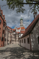 Obraz premium Augsburg, Stadtbummel durch das historische Ulrichsviertel in der Altstadt mit Blick auf die päpstliche Basilika St. Ulrich der romantischen Schwabenstadt am Lech. Schwaben, Bayern, Deutschland.