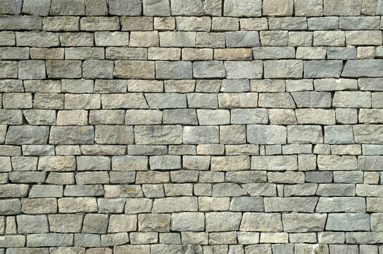 Gray chiseled stone block wall masonry texture background