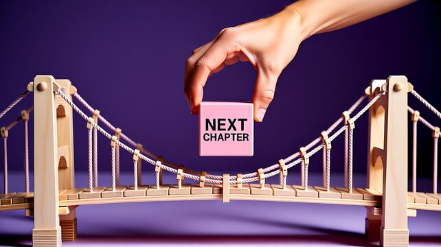 Hand placing next chapter block over bridge symbolizing new beginning and future progress