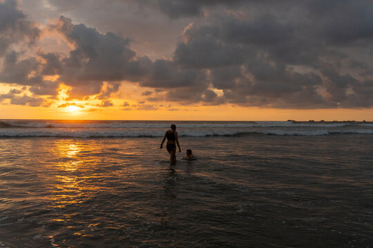 Mother and child enjoying a beautiful ocean sunset