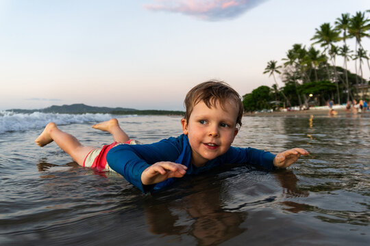 Young boy playing in the shallow water at the beach