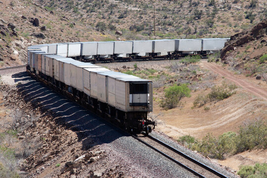 Long freight train winds through a desert landscape