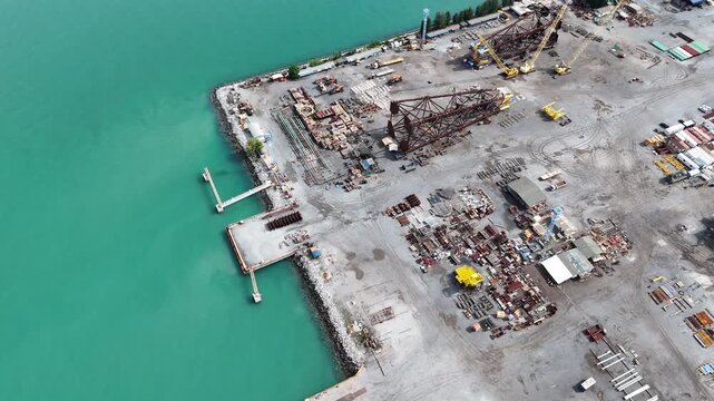 assembles large drilling rig structures next to the sea for easy transport onto ships. shipyard for transporting large structures onto ships.	