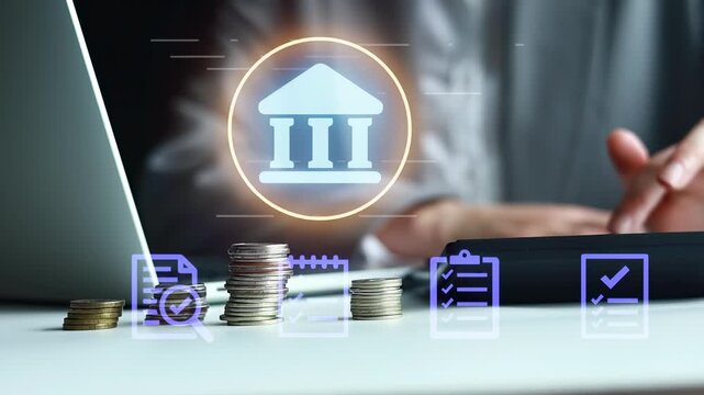 A person works at a table with a laptop, coins stacked beside it, and bank symbols in the air. The setting shows a focus on finance and technology.