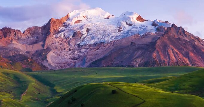 Time-lapse footage of Genie Holy Mountain, snow-capped glacier peak above alpine meadow at sunrise, western Sichuan plateau landscape, Sichuan China