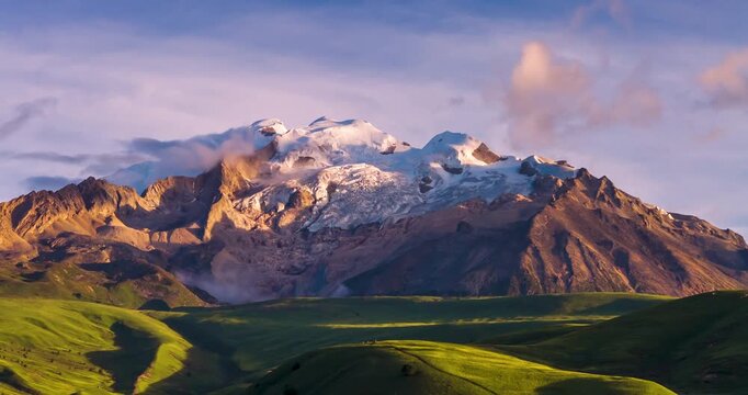 Time-lapse footage of Genie Holy Mountain, snow-capped glacier peak above alpine meadow at sunrise, western Sichuan plateau landscape, Sichuan China