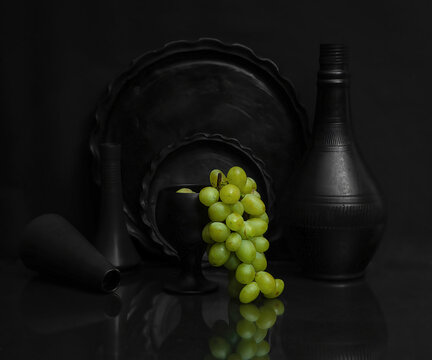 Still life utensils with grapes decorated in a dark background. Selective focus.
