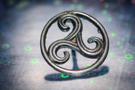 Metal triskel symbol representing motion, balance and Celtic spiritual heritage