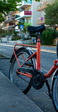 Red bicycle parked along a quiet urban street in northern Italy