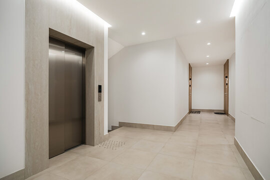 Elevator hall with stainless steel doors and beige floor tiles