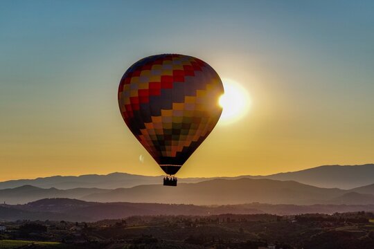 Heissluftballon &uuml;ber der Toskana bei Sonnenaufgang &ndash; Ballonfahrt &uuml;ber H&uuml;gel und Zypressen, Italien