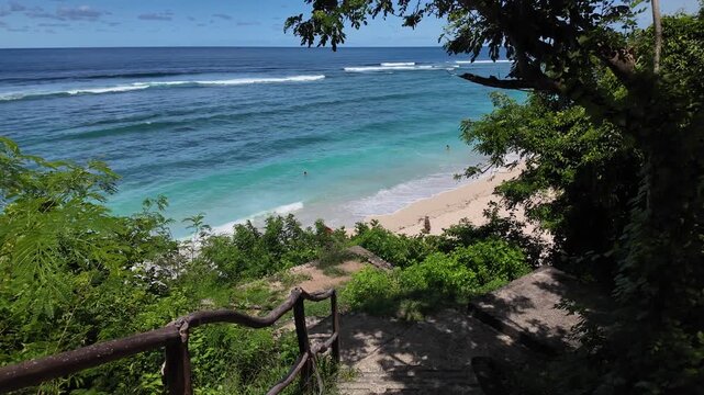 Beachgoers on a secluded cove beach at Gunung Payung, Bali