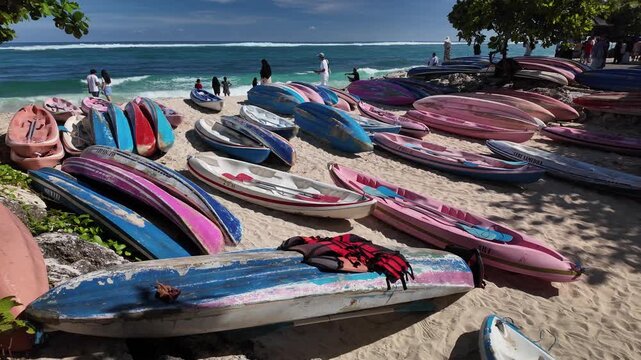 Colorful kayaks and canoes lined up on the beach at Pandawa, Bali