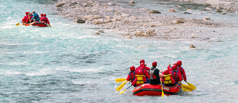Rafting groups navigate turquoise river rapids, embodying extreme outdoor adventure lifestyle for active summer tourism within the remote Julian Alps Natural Park, Resia, Friuli Venezia Giulia, Italy.