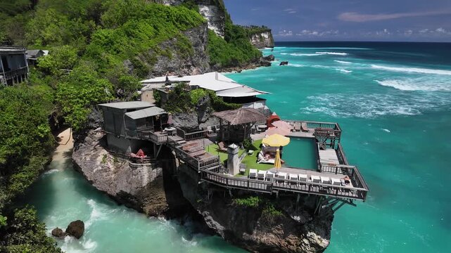 Wooden clifftop cafe overlooking turquoise waves at Uluwatu, Bali