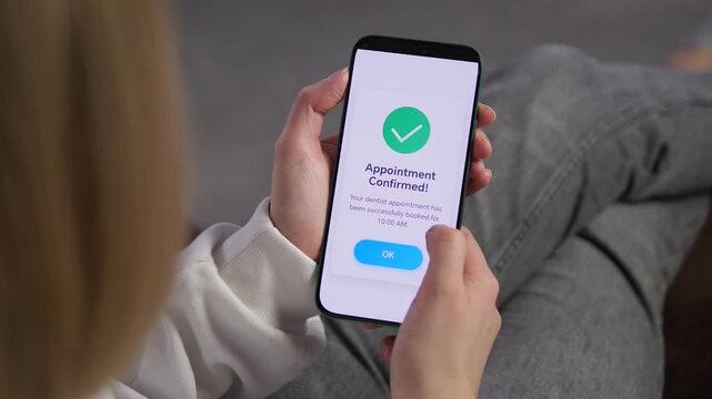 Woman receives dental appointment confirmation on her phone, capturing the shift toward mobile health management and fast online access to routine care.
