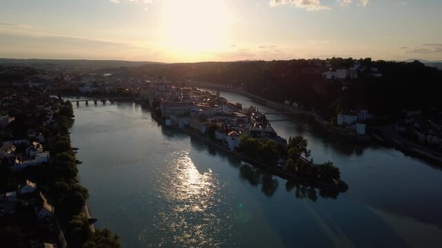 Aerial orbit of Passau old town and Veste Oberhaus at the confluence of three rivers at sunset