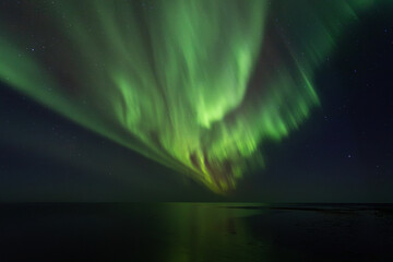 Bight and intense Northern Lights Aurora Borealis in the dark night sky above Iceland and the Atlantic Ocean © Richard Waghorn