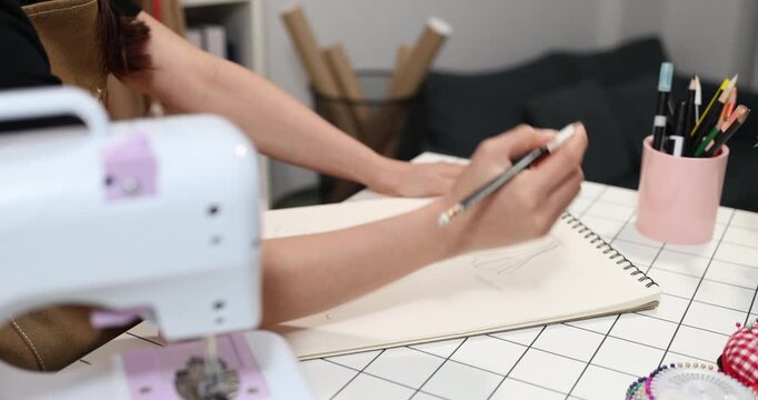 Fashion designer creating garment patterns, measuring fabric, inspecting clothing quality, and preparing apparel in a professional studio for tailoring, production, and fashion design workflow.
