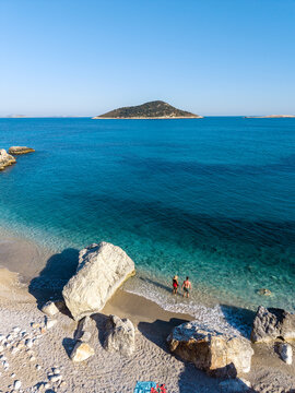 Stunning Gerenlik Beach in Kas Antalya, Turkey with couples enjoying the sunlit shore