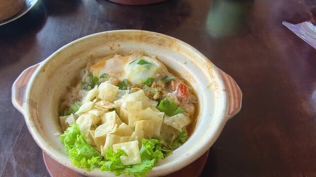 Delicious noodle soup served in a ceramic pot with fresh ingredients and garnishes perfect for culinary content food blogs and restaurant menus featuring savory Asian cuisine