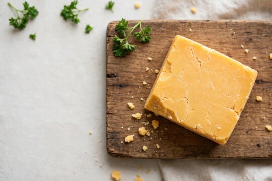 Block of Yellow Cheese on Wooden Board
