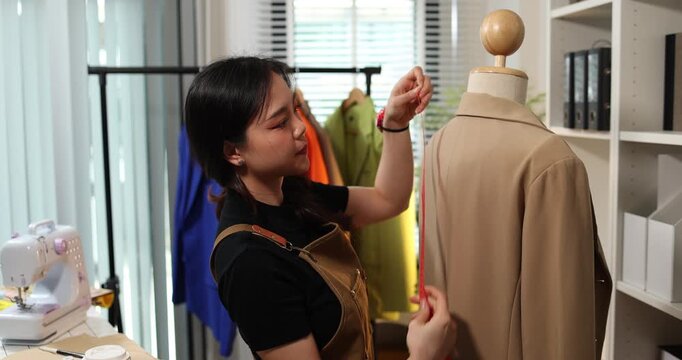 Fashion designer creating garment patterns, measuring fabric, inspecting clothing quality, and preparing apparel in a professional studio for tailoring, production, and fashion design workflow.