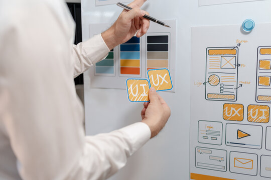 Close-up of a UX designer arranging wireframes and interface components while planning a digital product. Creative workflow for user experience, prototyping, and modern app design.