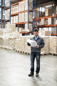 Logistics, man and reading paperwork in warehouse for receiving inspection, track stock or shipping. Export, inventory controller or clipboard to verify supplier invoice, storage oversight or picking