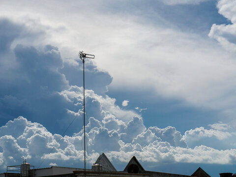 The antenna on the roof and the layered cloud cover at midday