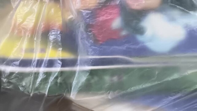 Transparent Wrinkled Plastic Sheet Covering Colorful Background Close Up