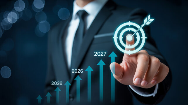 businessman hand pointing at target icon with year 2027 and multiple growth charts in dark setting.
