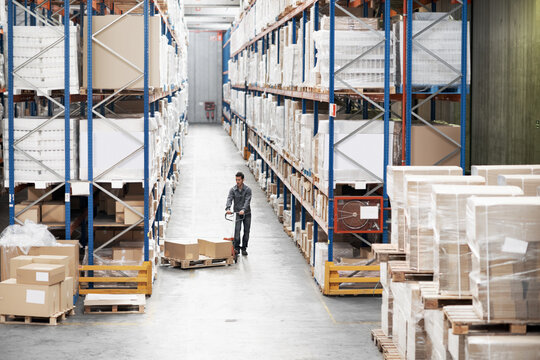 Above, logistics and pallet jack with man in warehouse for delivery, cargo trolley and inspection. Supply chain, distribution and freight storage with person in factory for inventory supervisor
