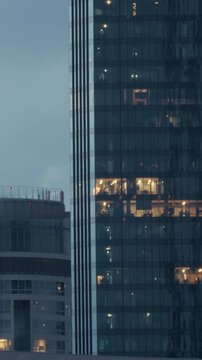 Modern office skyscraper buildings business district interior window lights night. High angle view showing illuminated glass windows of modern corporate office skyscrapers in a financial 