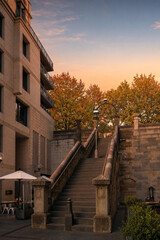 Fototapeta premium Historic stone stairs in Sydney city at sunset with autumn trees and orange sky