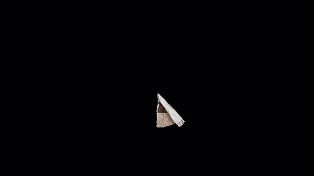 A sequence showing a piece of brown textured material unfolding on a black background.