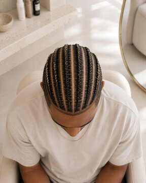 Man with braided hairstyle sitting in a salon chair