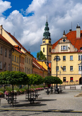 Obraz premium 2025-09-03; Charming old town square with cobblestones, benches and a high spire. Bystrzyca Klodzka. Poland.