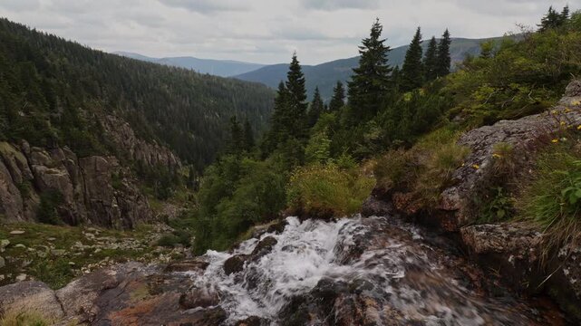 Scenic view of Elbe Waterfall flowing into Elbe Valley under a cloudy sky, Krkonose National Park, Czech Republic