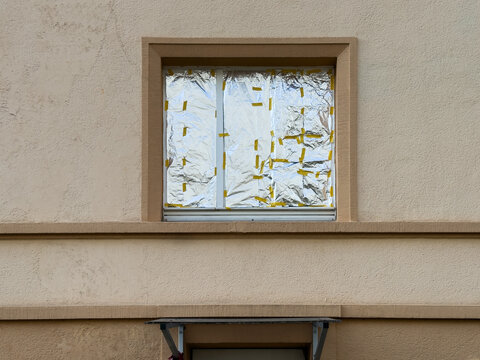 Fenster einer Hausfassade, das von innen vollst&auml;ndig mit Alufolie abgeklebt ist &ndash; improvisierter Sonnenschutz oder Sichtschutz, Wuppertal, Deutschland