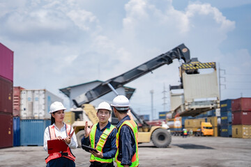 Fototapeta premium Container terminal workers coordinate lifting operation using tablet, clipboard and radio communication. Cargo inspection, logistics planning, shipping operations, warehouse management.