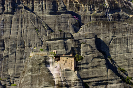 The Monastery of Agios Nikolaos Anapafsas perched on a rock formation in Meteora, Greece, under a clear sky.