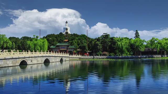 Captivating timelapse of Yongan Bridge and White Pagoda in Beihai Park, Beijing, with the changing sky and water reflections. A peaceful and serene scene showcasing the beauty of the park.