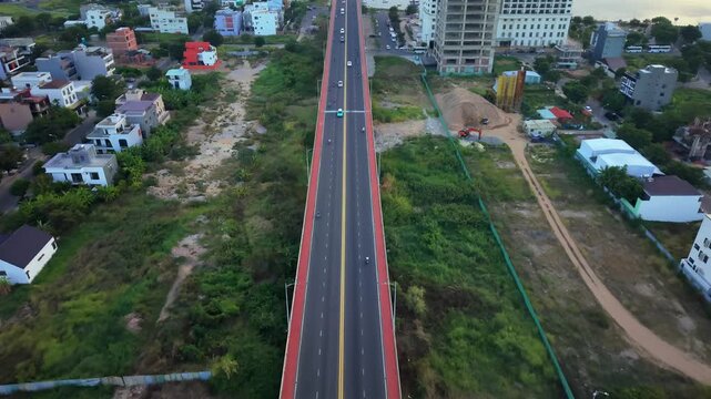 Drone descending toward a modern bridge over the Han River during sunrise with the Da Nang skyline in the background.