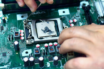Fototapeta premium A computer technician is installing a CPU.
